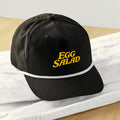 Egg Salad golf rope snapback — black cap with gold big-letter EGG SALAD embroidery, retro tournament style