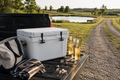 Premium hard cooler on a truck tailgate with cold drinks and summer country weekend gear